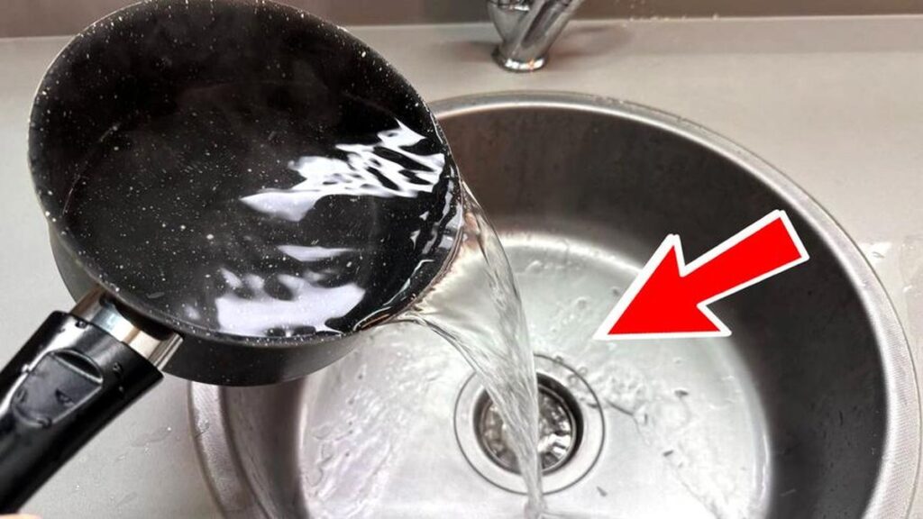 Acqua bollente versata nello scarico intasato della cucina
